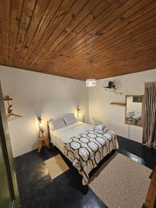 a bedroom with a bed and a wooden ceiling at Namastê Pousada e Camping in Cananéia