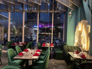 a restaurant with tables and chairs with red napkins at Elysium Grand Heights Facing Iconic Centaurus Mall Islamabad in Islamabad