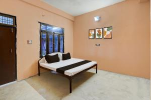 a bedroom with a bed and a window at Hotel O Guru in Jhūsi