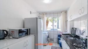 a kitchen with a refrigerator and a sink and a window at Apartamento em Sao Jose proximo a Arena Opus in Estêvão