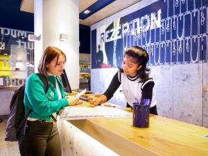 two women standing at a counter in a store at Ibis budget Berlin Potsdamer Platz in Berlin +84 photos