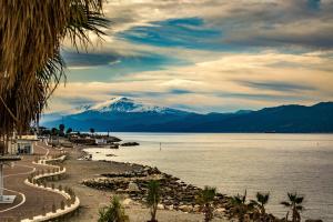 a view of a snow covered mountain next to a body of water at Omero in Reggio di Calabria