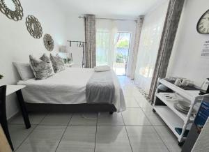 a bedroom with a bed and a clock on the wall at Zhantique Guest House 1- Unit 2 in Boksburg