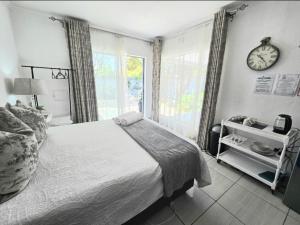 a bedroom with a bed and a clock on the wall at Zhantique Guest House 1- Unit 2 in Boksburg
