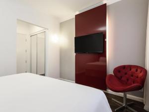 圣保罗圣保罗保利斯塔美居酒店的一间卧室，有一张床和一把红椅子 更多57张照片