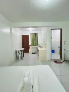 a white room with a bed and a bathroom at RB Baruiz "Hideaway" Inn - Cebu South in Cebu City