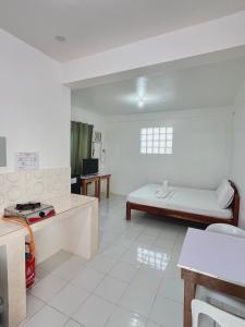 a white room with a bed and a table at RB Baruiz "Hideaway" Inn - Cebu South in Cebu City