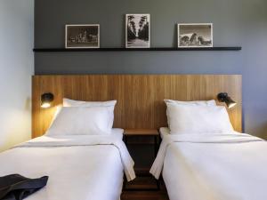 Dos camas una al lado de la otra en una habitación. en ibis Belo Horizonte Liberdade, en Belo Horizonte 52 fotos más