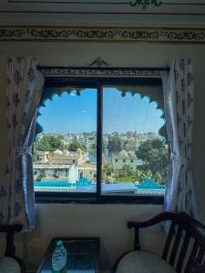 a window with a view of a city at Storica Stays Panorama Haveli Udaipur in Udaipur