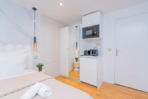 a white bedroom with a bed and a microwave at Luxurious Apartment Stylish Design - René Boulanger in Paris
