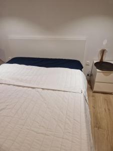 a white bed in a room with a night stand at Appartement Victoire in Bordeaux
