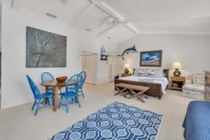 a bedroom with a bed and a table and chairs at 4201 Tenth Street in Saint Simons +71 photos