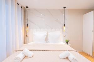 a white bedroom with a large bed with white pillows at Luxurious Apartment Stylish Design - René Boulanger in Paris +3 photos