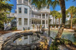 a large white house with a swimming pool and palm trees at 4205 Ninth Street in Saint Simons Island
