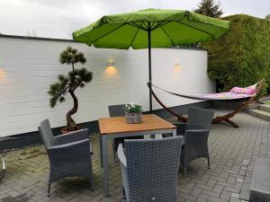 ボルンハイムにあるAppartement Köln in Bornheim-Sechtem, Nähe Phantasialand, Brühl, Köln, Bonn, DB-Anschluß, Messe-Köln, Business-Komfortのハンモックとテーブルと椅子、そして緑の傘