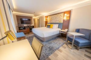 a hotel room with a large bed and a chair at The Westfield Inn, BW Signature Collection in Westfield