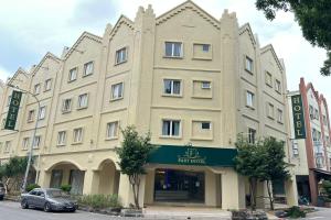 a large building with a car parked in front of it at Fast Hotel Melaka Near Menara Taming Sari - 2 Mins Only in Melaka
