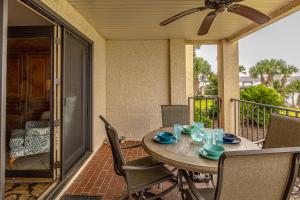 a wooden table and chairs on a balcony with a ceiling fan at Pier Pointe #104 in King City