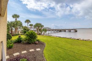 a grassy yard next to the water with a pier at Pier Pointe #104 in King City