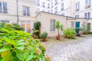 a courtyard with plants in front of a building at Luxurious Apartment Stylish Design - René Boulanger in Paris