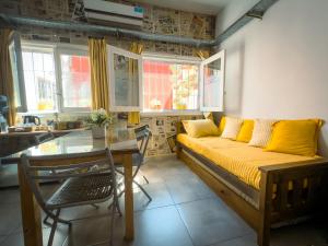 Una sala de estar con un sofá y una mesa de cristal. en La Redacción Apartamentos, en San Pedro