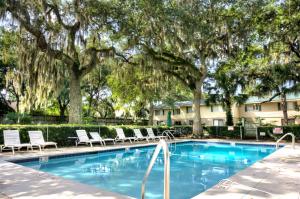 una piscina con tumbonas y árboles en Island Townhouse #E1, en East End