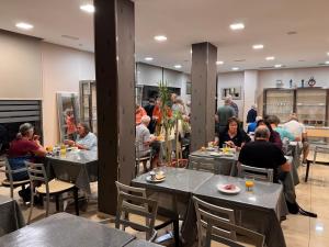 a group of people sitting at tables in a restaurant at Hotel Villa de Cacabelos in Cacabelos