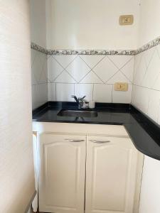a small kitchen with a sink and a counter at Hermoso Chalet en Paso frente al río in Paso de la Patria