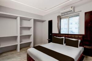 a bedroom with a bed and shelves and a window at HOTEL O STAY INN RESIDENCY in Upal