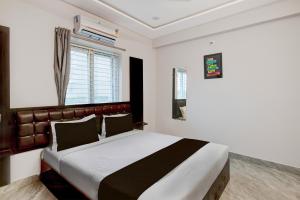 a bedroom with a large bed and a window at HOTEL O STAY INN RESIDENCY in Upal +38 photos