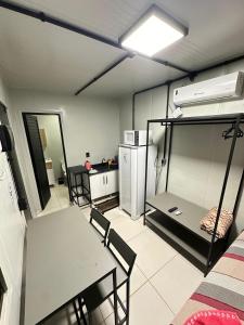 a room with a table and chairs and a kitchen at Loft privativo próximo ao Amaral in Jaú