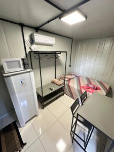 a small kitchen with a refrigerator and a table at Loft privativo próximo ao Amaral in Jaú