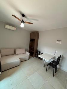 a living room with a couch and a table at Loft próx. Amaral C. e Shopping in Jaú +3 photos