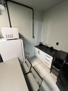 a small kitchen with a laptop on top of a refrigerator at Apartamento estruturado próx. Amaral C. in Jaú
