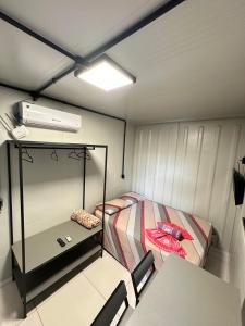 a small room with a bed and a table at Apartamento estruturado próx. Amaral C. in Jaú