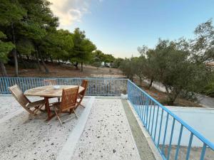 a wooden table and chairs sitting on a balcony at Eva's house in Rafina