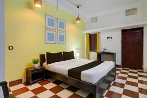 a bedroom with a large bed and a checkered floor at Hotel O Rose Inn in Bālianta +21 photos