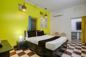 a bedroom with a bed and a yellow wall at Hotel O Rose Inn in Bālianta