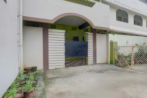 a building with a garage with a blue door at Hotel O Rose Inn in Bālianta
