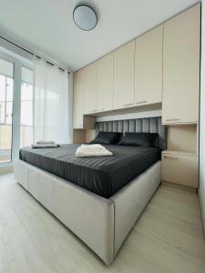 a bedroom with a large bed with white cabinets at Richy North in Voluntari
