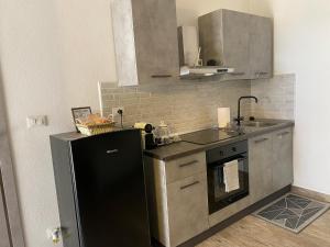 a kitchen with a black refrigerator and a sink at Chagall Charme in Asti +9 photos