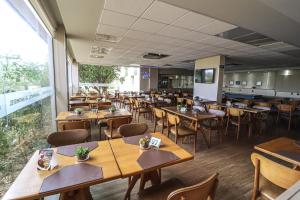 a dining room with wooden tables and chairs at Strassen Hotel in Aparecida de Goiânia