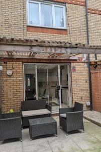 a group of wicker tables and chairs in front of a building at 3SIEE Homes in Luton