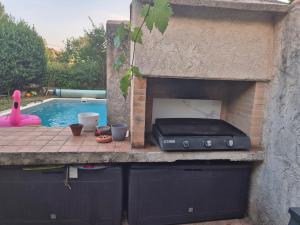 a outdoor oven with a pool in a backyard at Studio au calme avec jardin in Gardanne