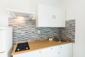 パシュマンにあるMama Rozaの白いキャビネットとシンクのあるキッチン