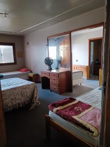 a hotel room with two beds and a mirror at Mamma's Hostel e Pousada in Caxias do Sul