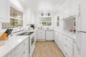 a white kitchen with white cabinets and white appliances at 233 Cedar Street in East End