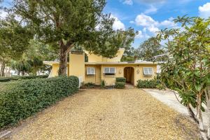 a yellow house with a tree and a driveway at 233 Cedar Street in East End