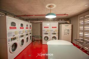 a laundry room with three washer and dryer machines at Indigo at 11, City Views and Wonderland Vibes! in Hatillo +61 photos