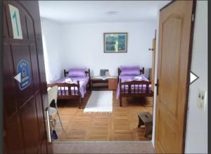 a small room with two beds and a hallway at Apartmani Da-Da in Gornji Milanovac